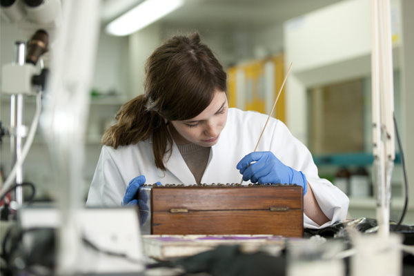 A student working on conservation of a historic object in a laboratory