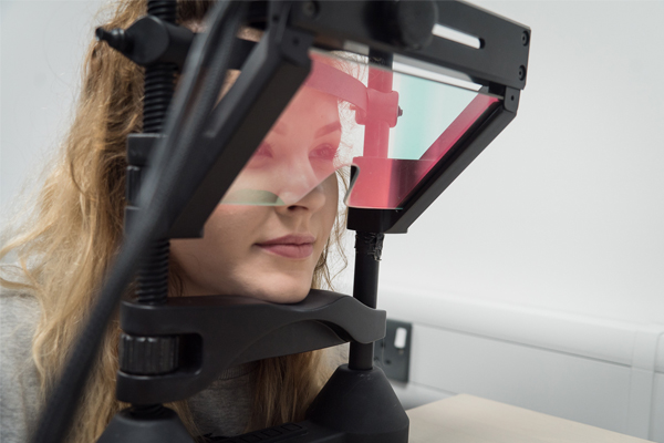 A student sat with their head on an eye tracking machine