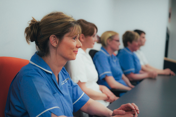 Nurses sat in a row facing something off camera