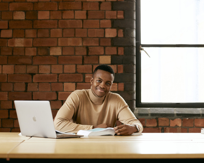 A student sitting at a table with a computer