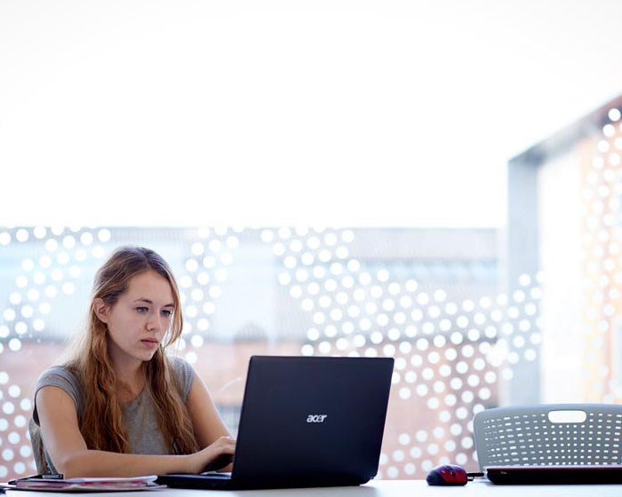 A student sitting at a table with a laptop