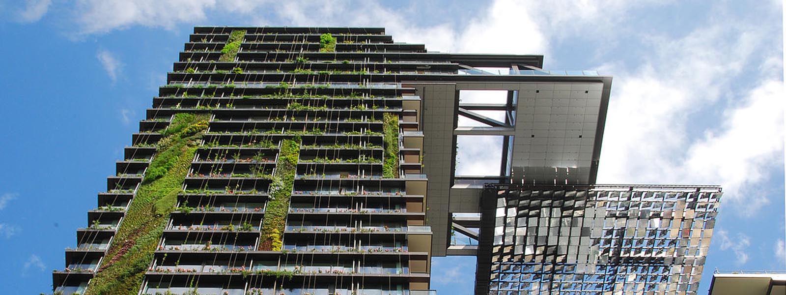 A high rise building with solar panels and greenery