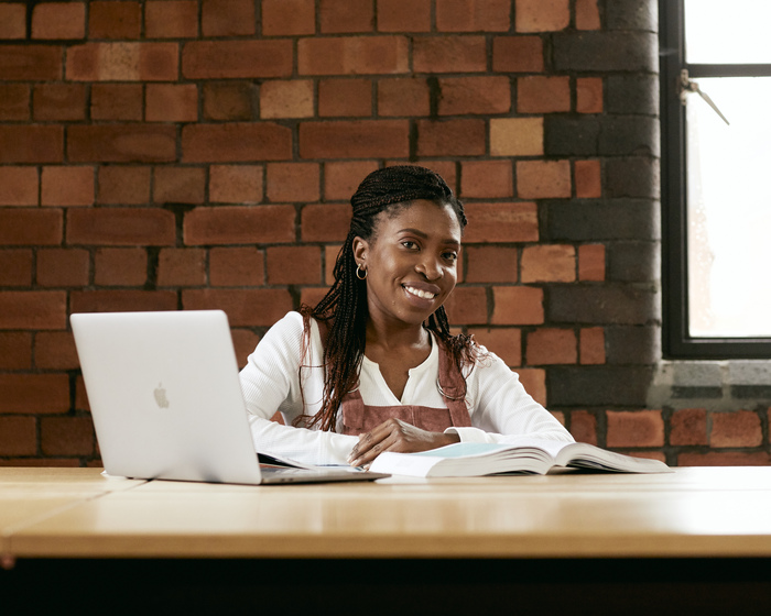 A student studying in the library with a laptop