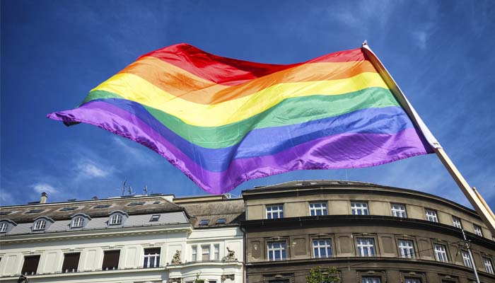 Rainbow flag flying in front of buildings