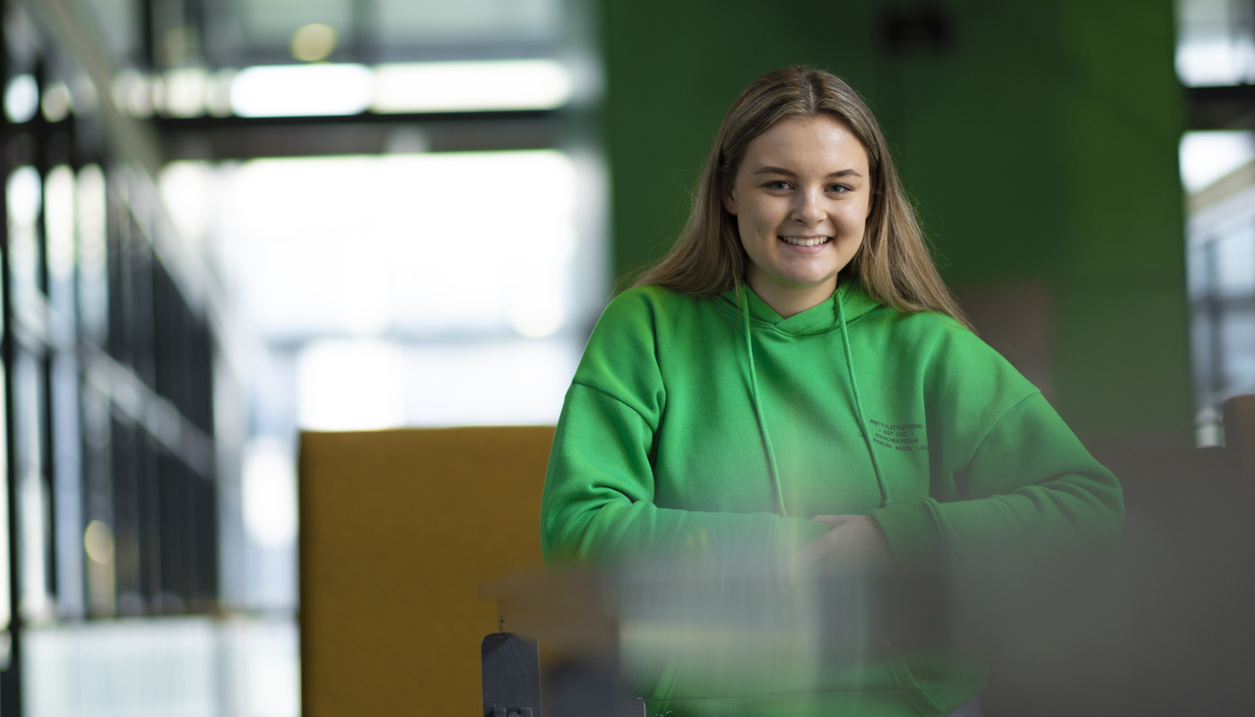 A student wearing a green hoodie