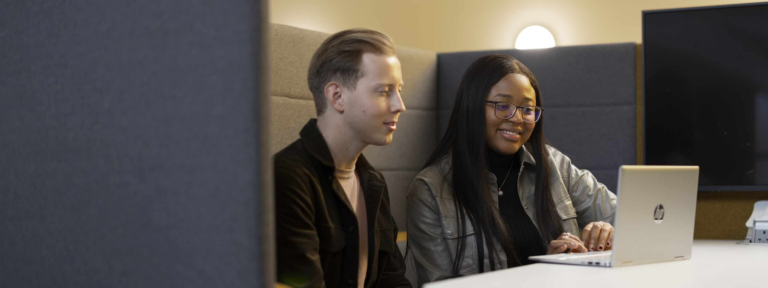 Two students watching a video on a laptop