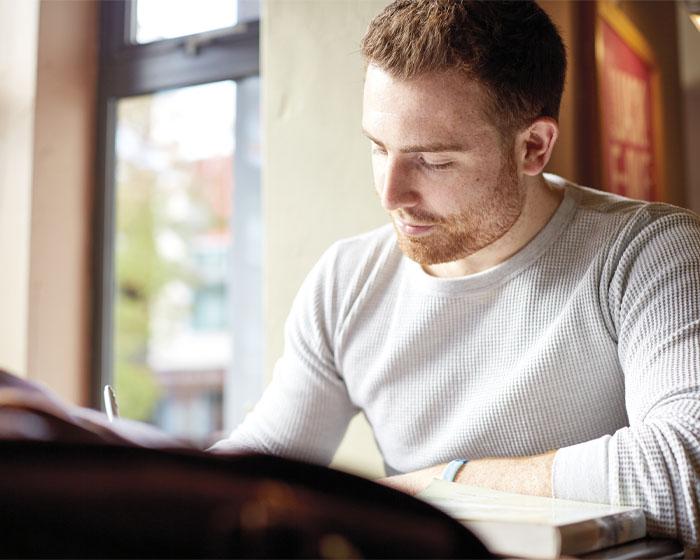 A student sat writing at a desk