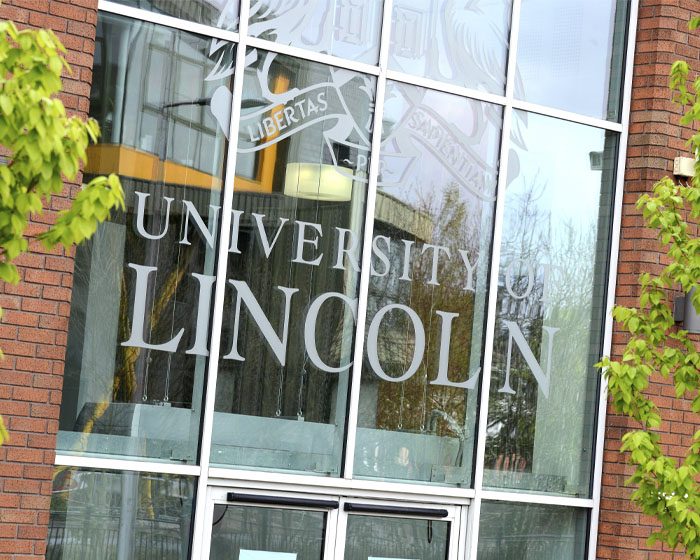 The University of Lincoln logo on the windows of a campus building