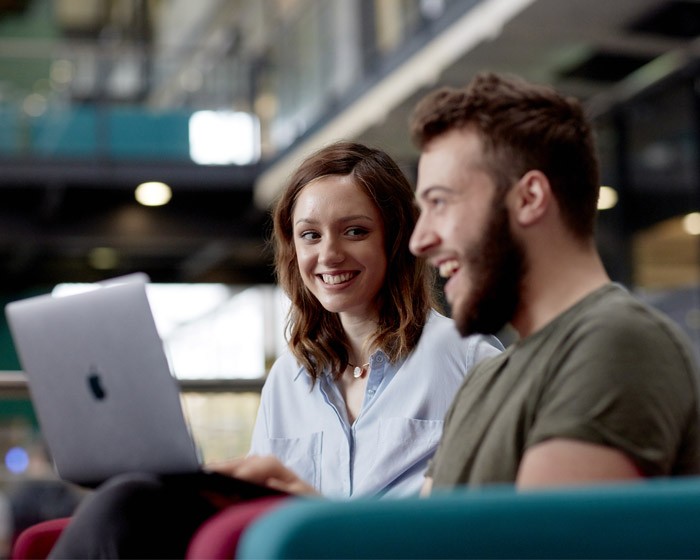 Two students working together on a laptop