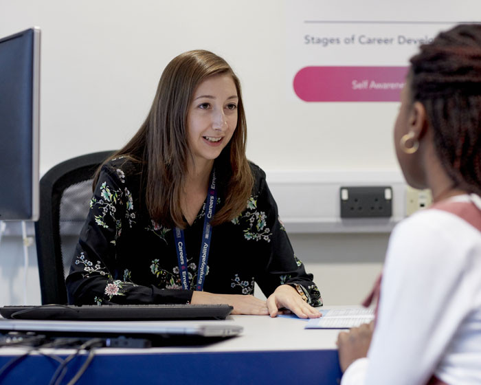 A member of staff advising a student in the support centre