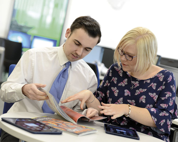 A member of staff offering advice to a student