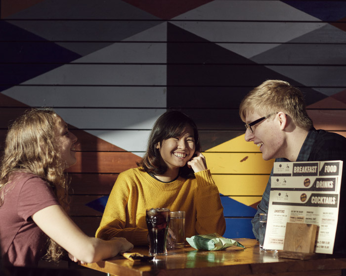 A group of students sitting eating and chatting in a University cafe