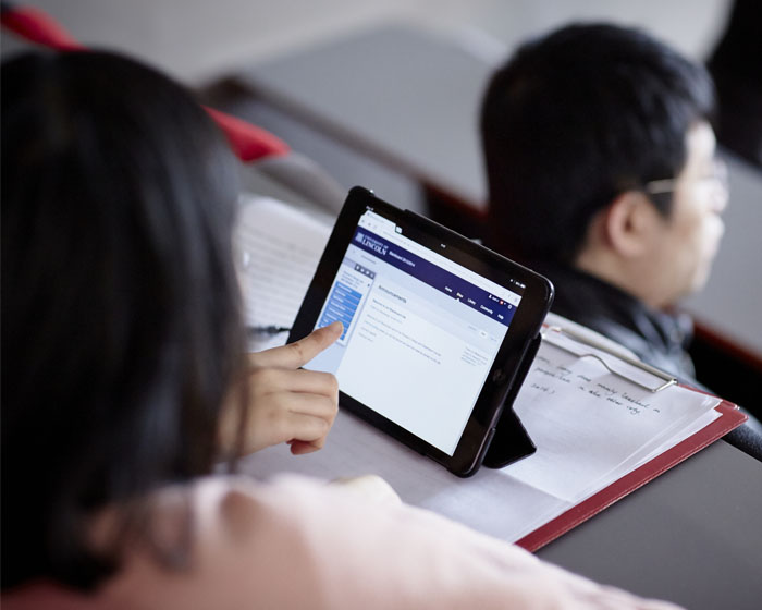 A student taking notes on a tablet device during a lecture