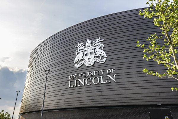The University of Lincoln logo on the side of a large building on campus
