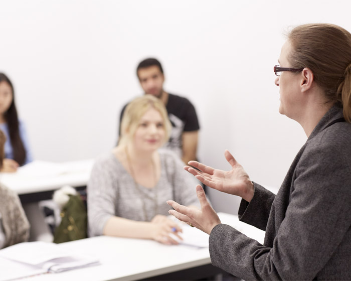 A member of staff presenting to a group of students in a seminar room