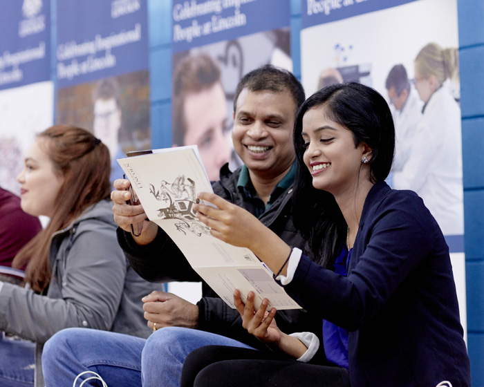 A father and daughter reading through the visitor guide during an Open Day event