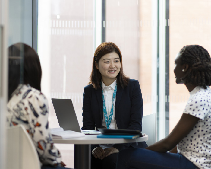 A group of students sitting at a desk in an office