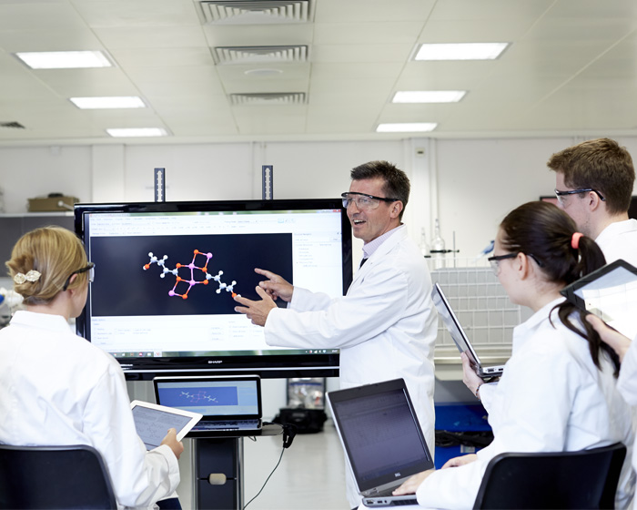 An academic teaching a group of students in a science lab