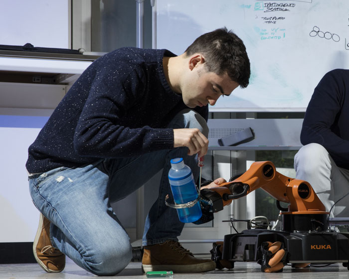 A student working on a robot in a science lab