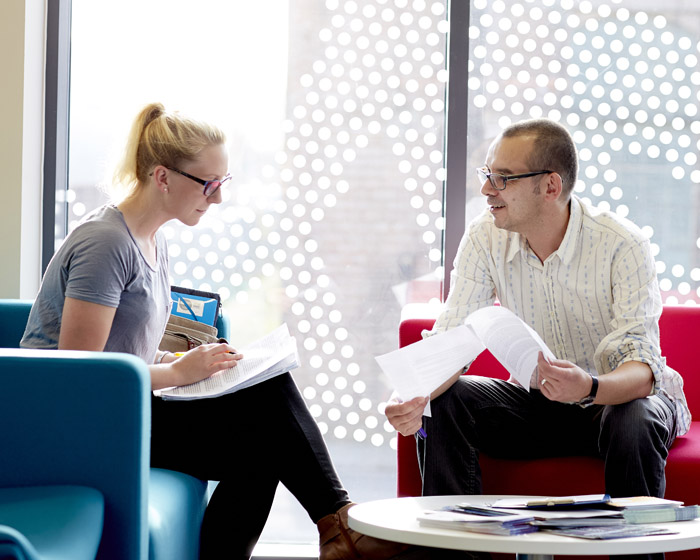 Two students sat talking on campus