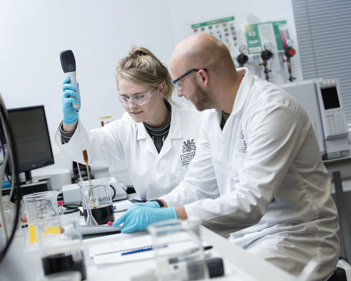 An academic and student working together in a science laboratory