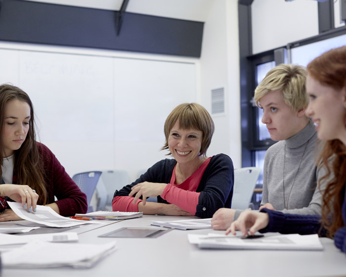 A group of students sitting around a table in a seminar room