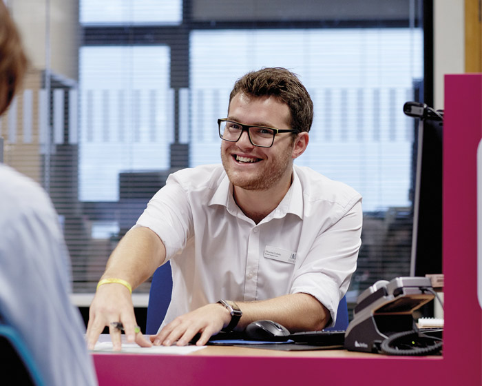 A member of staff talking to a student in the support centre