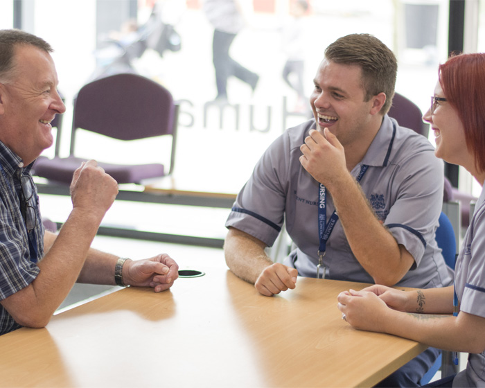 Two medical students talking to a member of staff