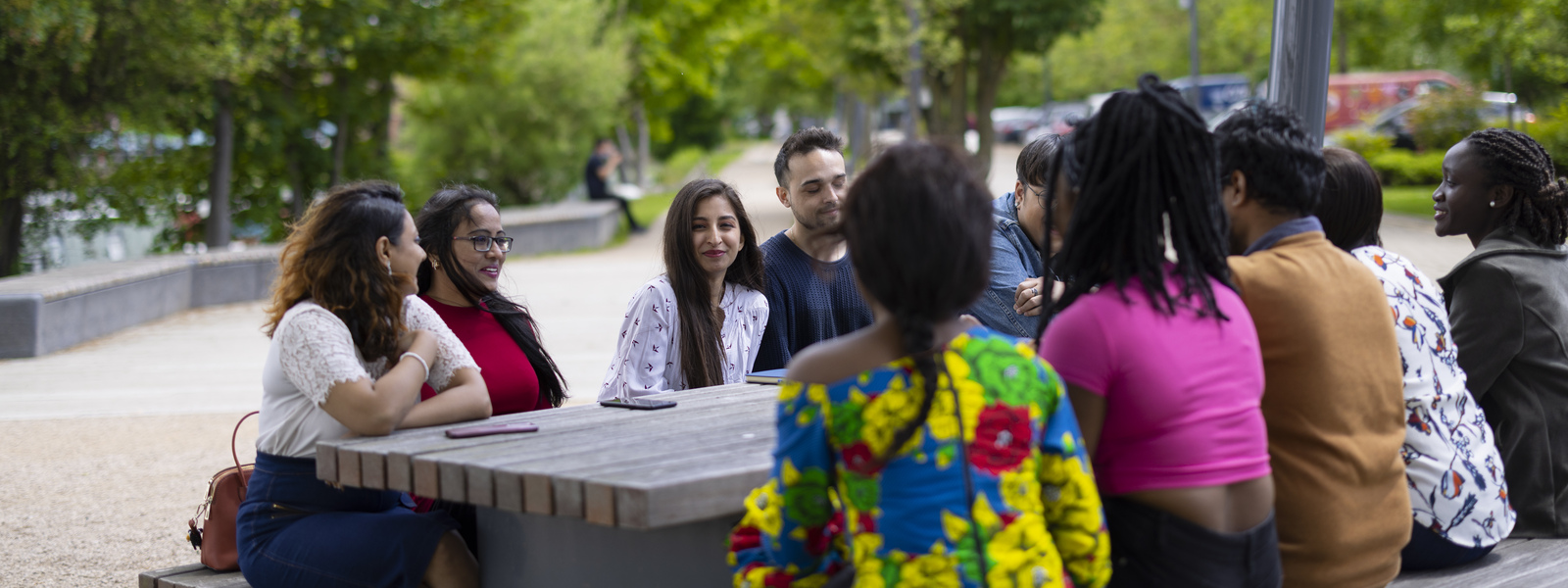 Students chatting on a bench on campus