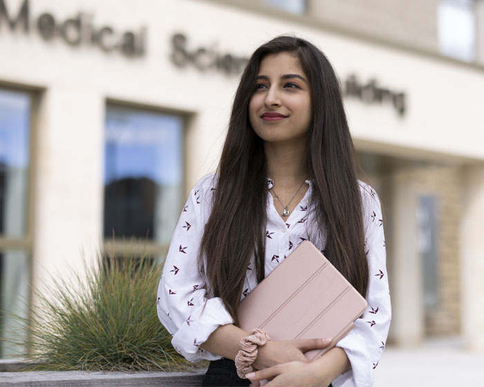 A student standing outside the Lincoln Medical School on campus