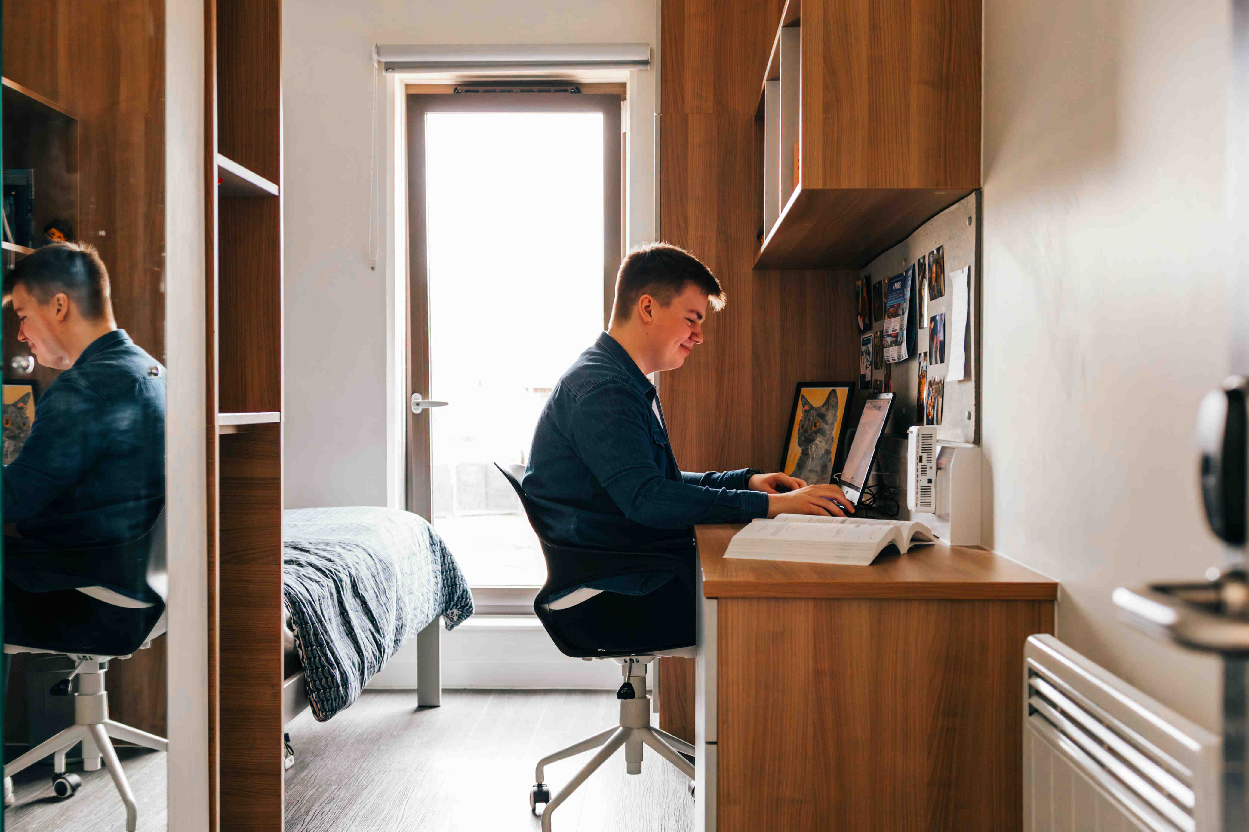 A student sat at a desk smiling