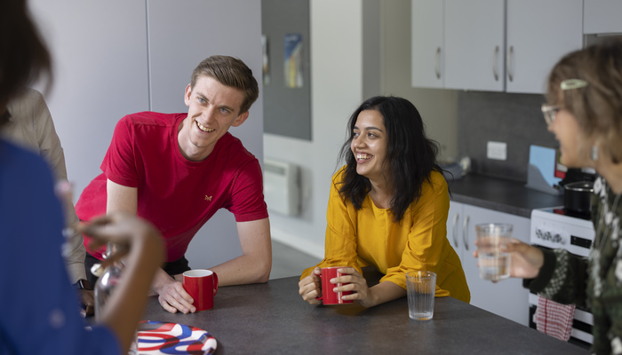 Students chatting in a kitchen space