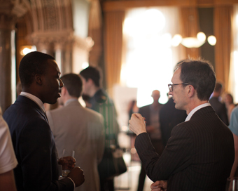 Two men in black suits, conversing in the Lincoln Cathedral