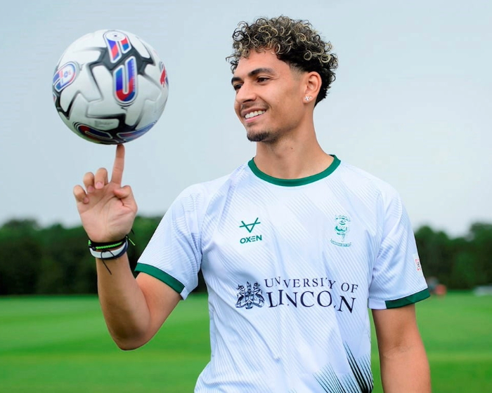 Lincoln city FC player football kit, spinning a football on his finger