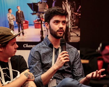 Man sat in a chair, speaking into a microphone