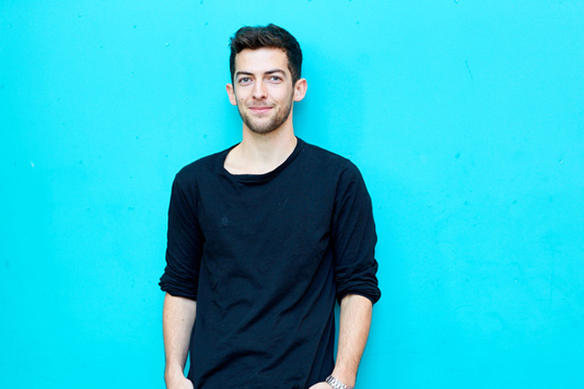 A student stood in front of a teal background