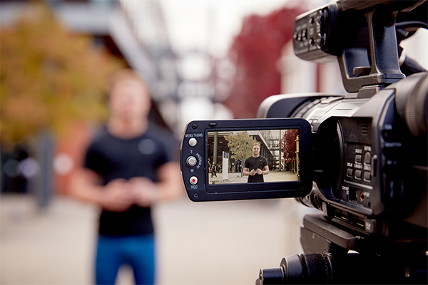 A student stood being filmed