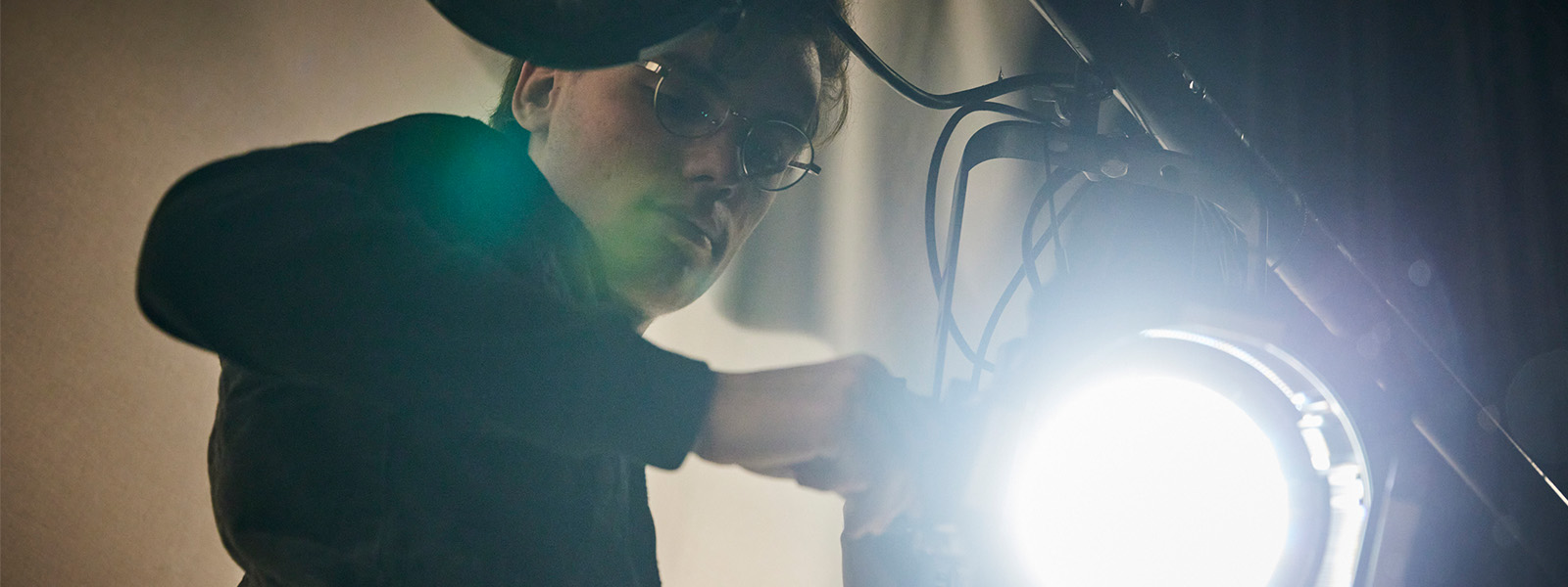 A student adjusting a stage light