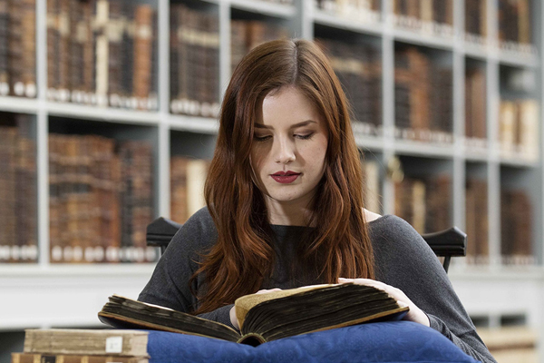 A student sat in a library reading an old book
