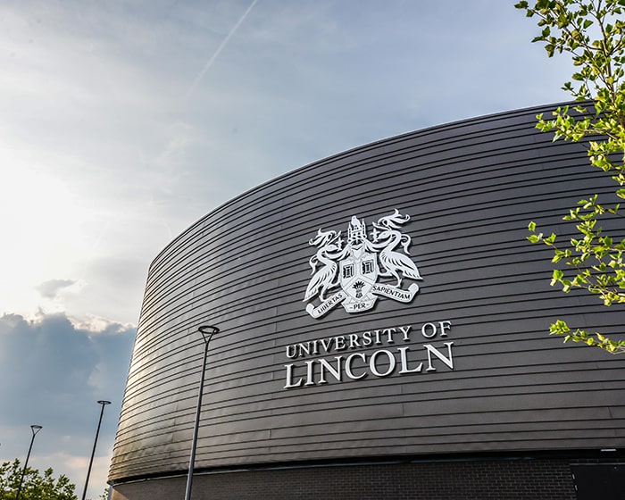 Side of the Isaac Newton Building at the University of Lincoln, displaying the University crest