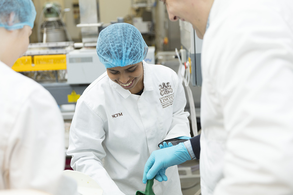 Student in white lab coat and hair net at the National Centre for Food Manufacturing