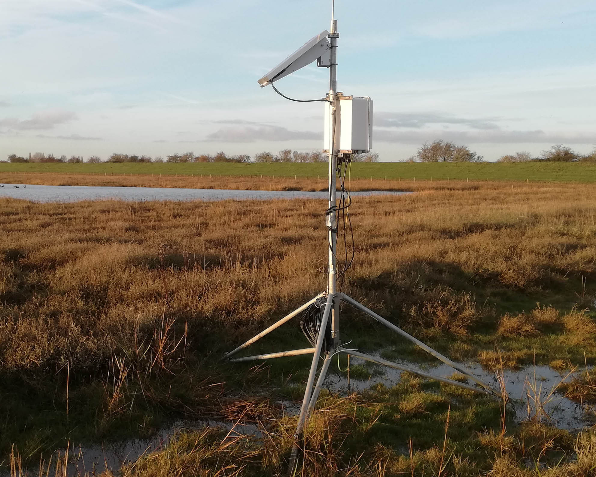 Observation equipment on a tripod, stood in a waterlogged field