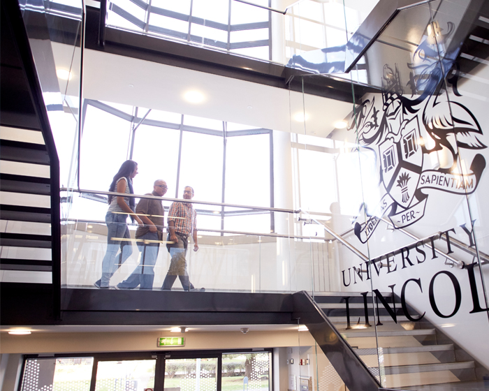 Three students walking down a flight of stairs in the joseph banks building