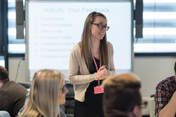 A woman talking to a group of students