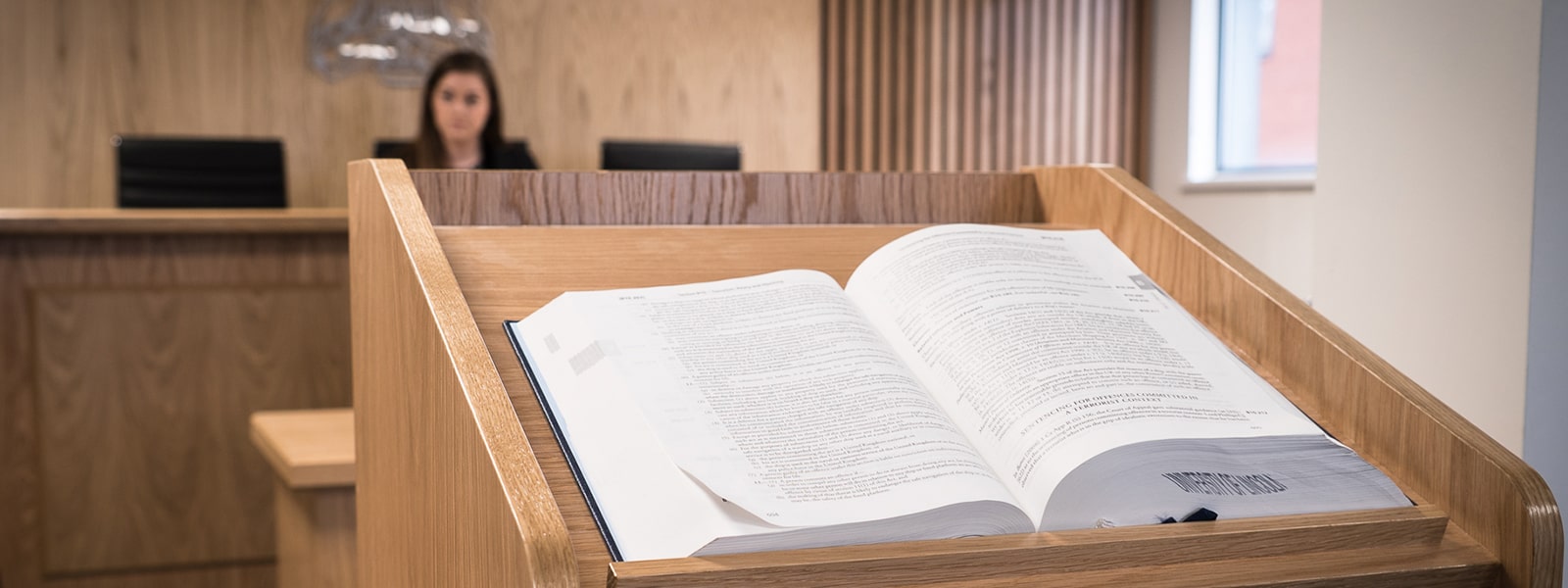 Law book open with student in background