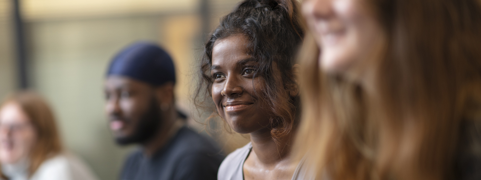 Student sitting smiling in a classroom setting