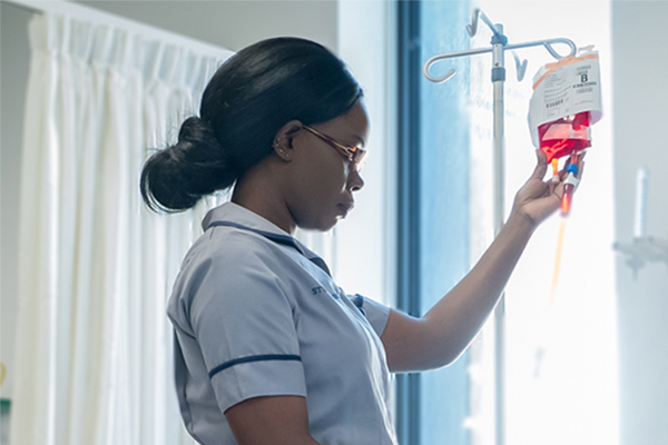 A woman checking an IV bag