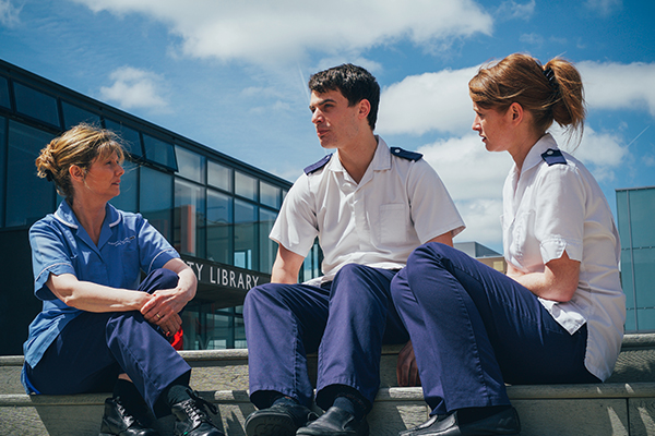 Three nurses sat outside