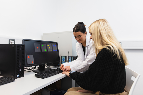 A student working with a test subject at a machine