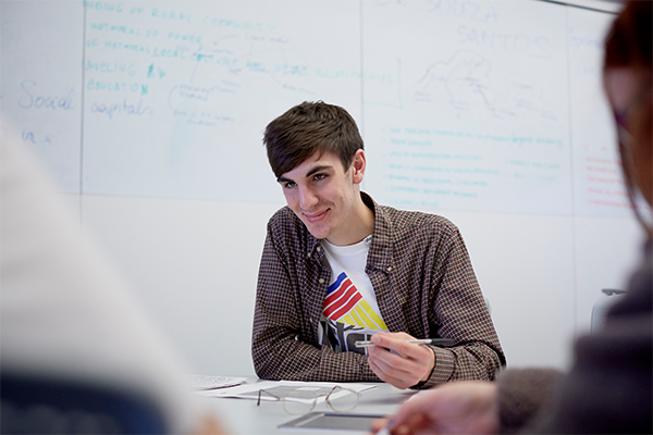 A student sat at a desk smiling